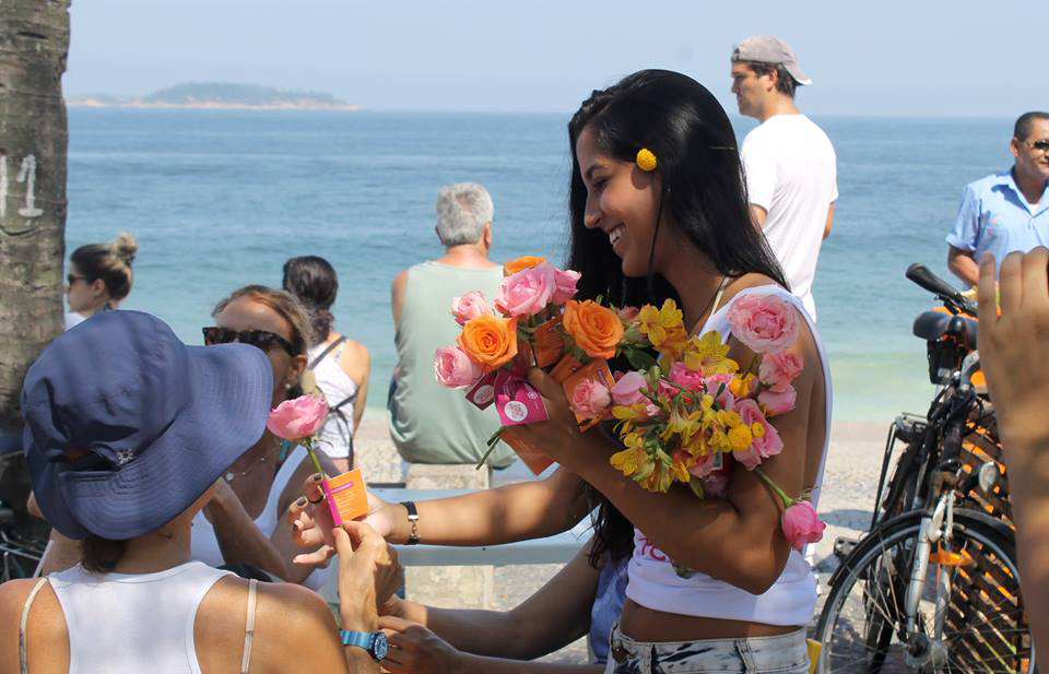 Voluntária distribui flores na orla de Ipanema