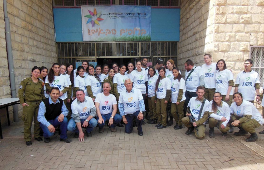 Israeli soldiers help paint a building