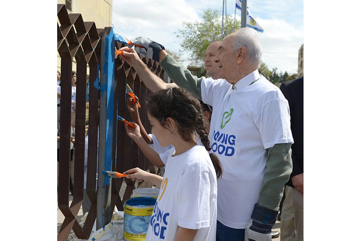 President Peres painting on Good Deeds Day (photo credit: Mark Neiman, GPO)