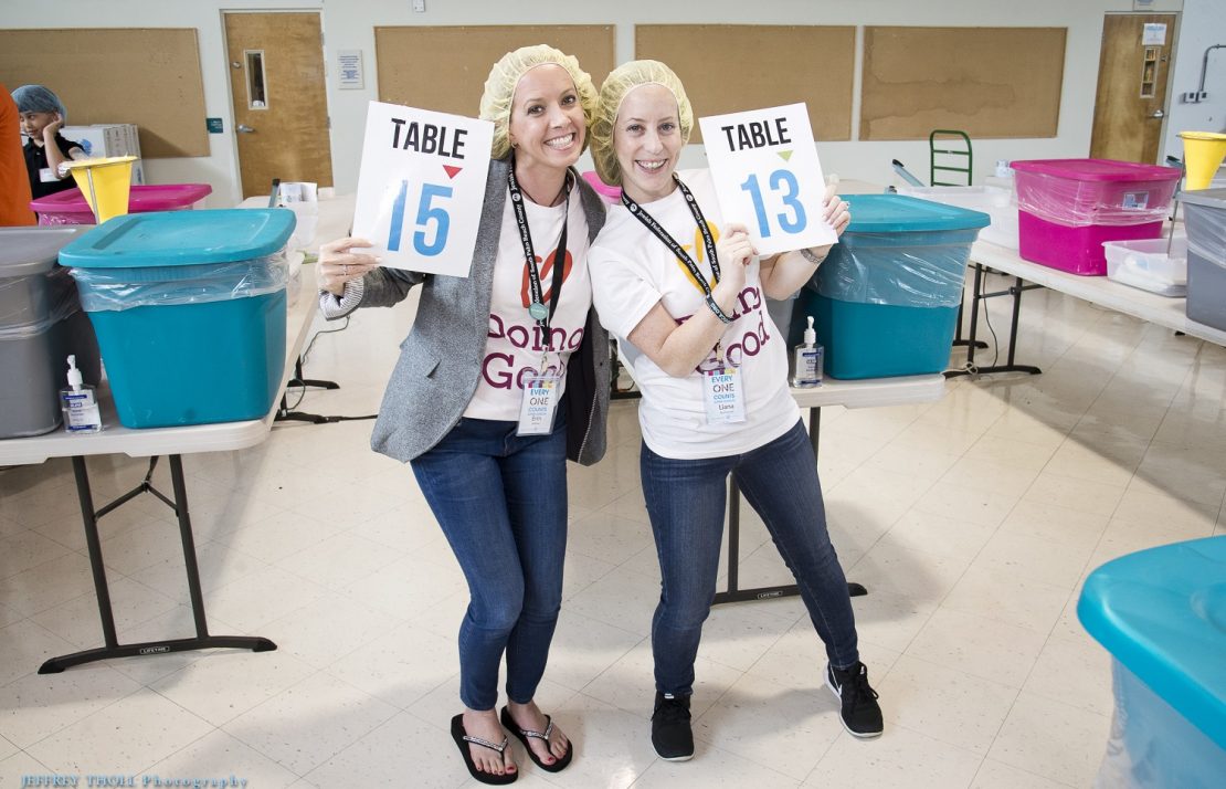 Volunteers from the Jewish Federation of South Palm Beach County smile wide during a food drive.